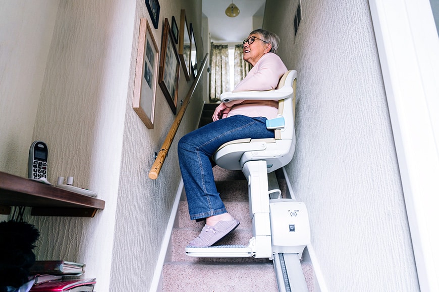 Woman using stair lift in her home