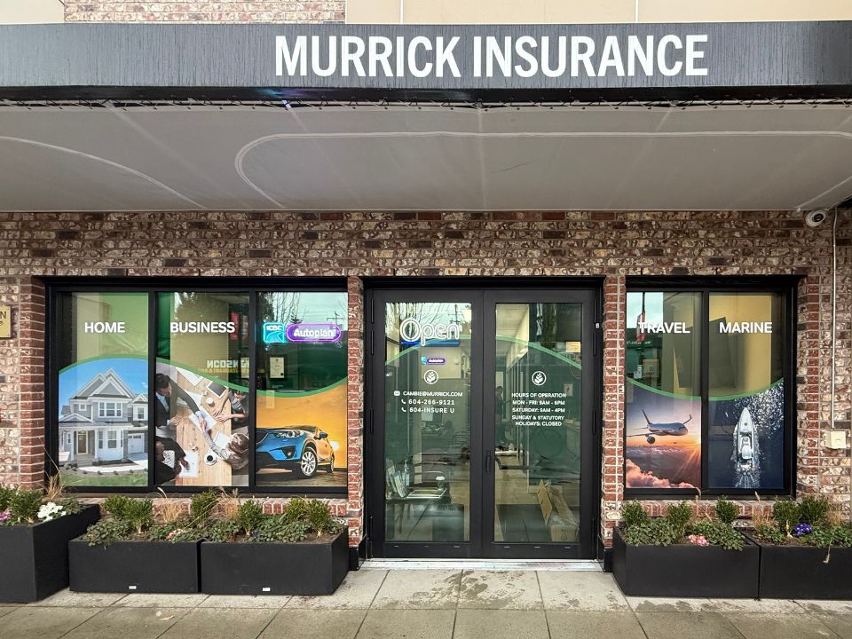 Front entry of Murrick Insurance on Cambie Street. The glass windows have colourful signage showing home, business, travel, marine insurances